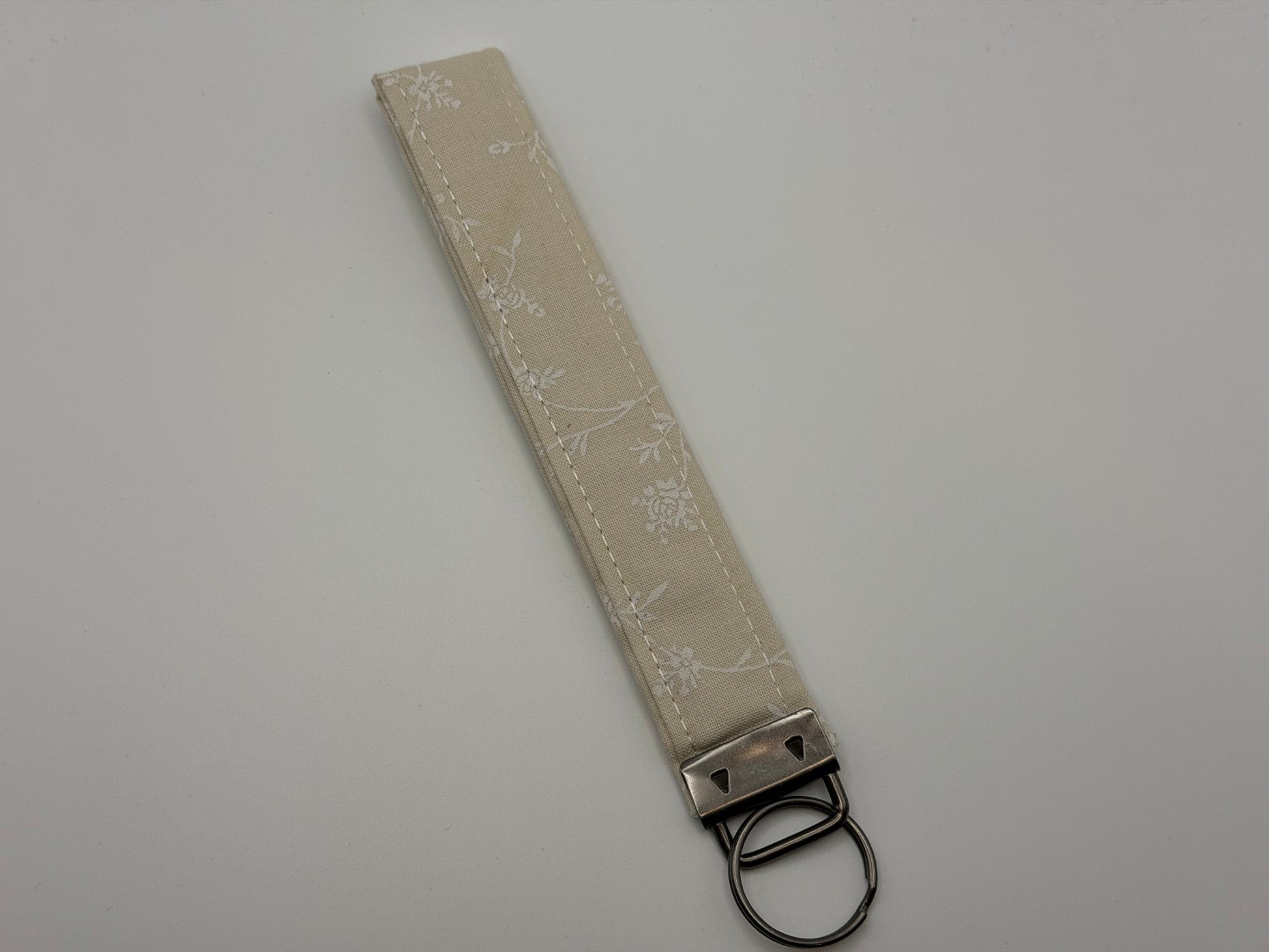 Cream ivory floral jacquard key fob wristlet with silver swivel clip