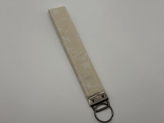 Cream ivory floral jacquard key fob wristlet with silver swivel clip