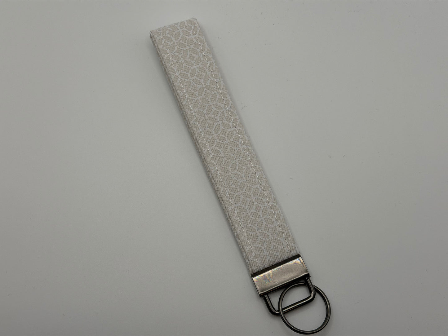 White iridescent holographic key fob wristlet with gunmetal D-ring hardware