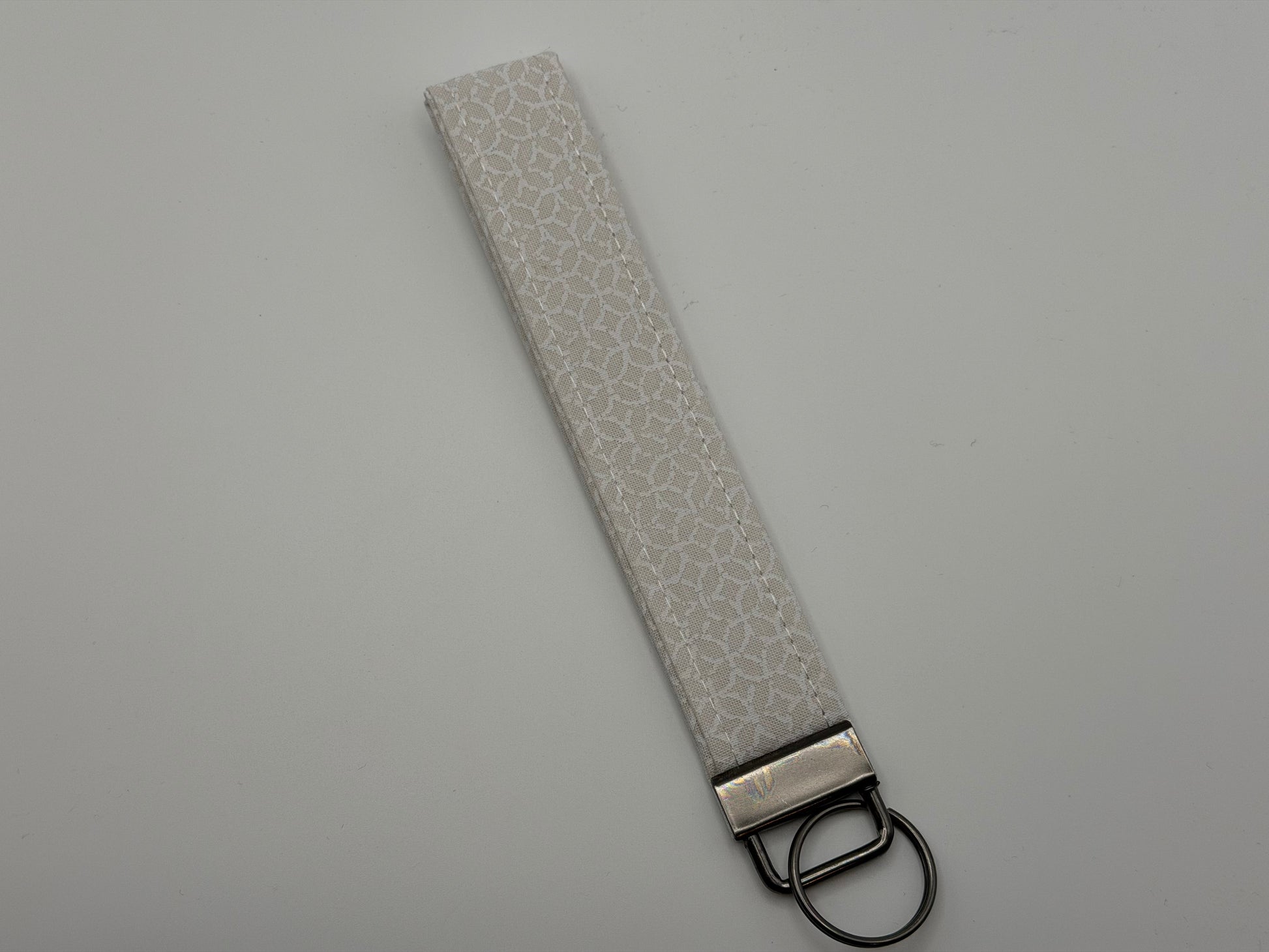 White iridescent holographic key fob wristlet with gunmetal D-ring hardware