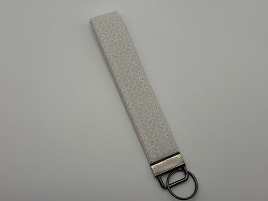 White iridescent holographic key fob wristlet with gunmetal D-ring hardware